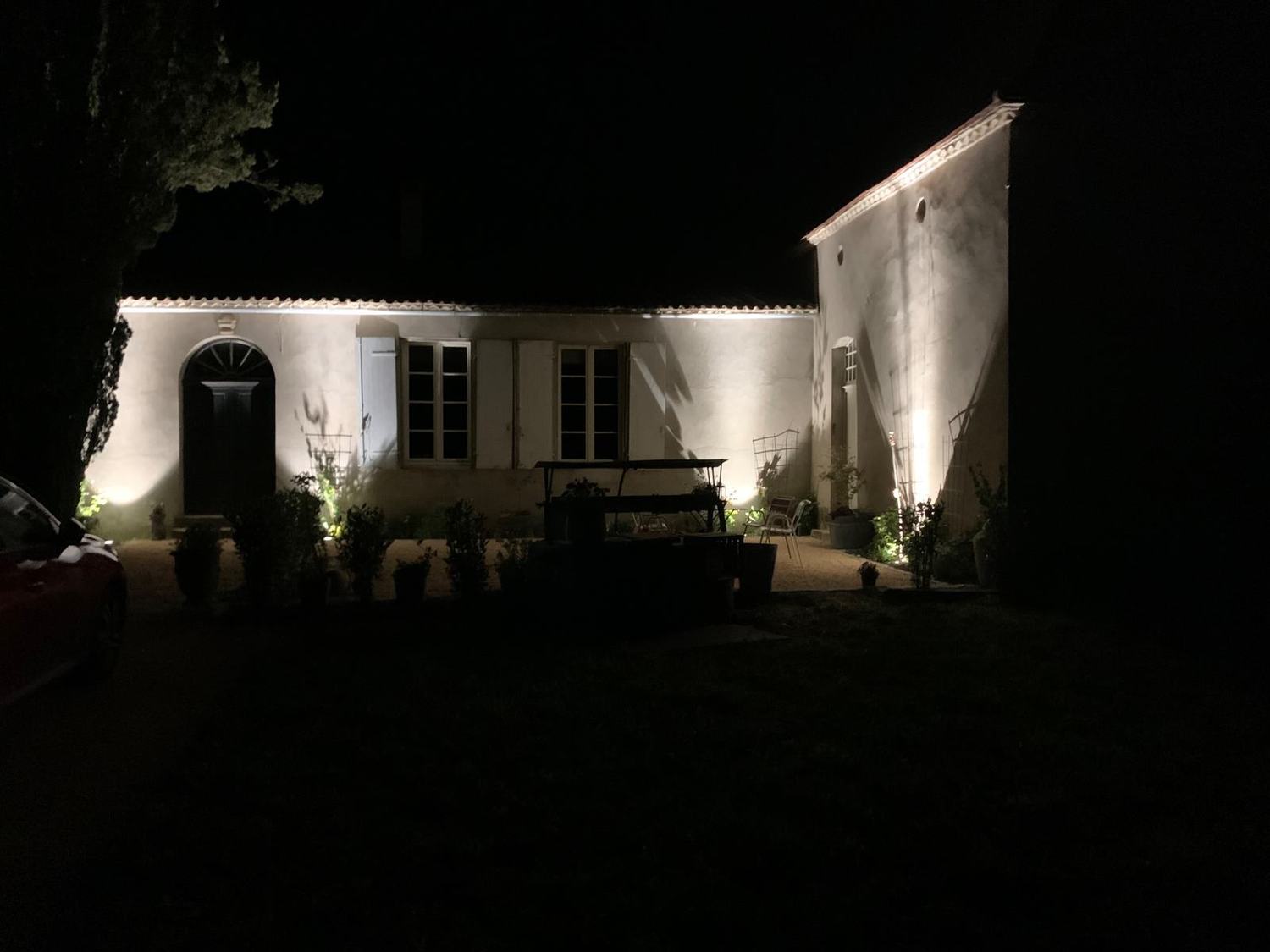 Éclairage extérieur de nuit d'une maison en pierre